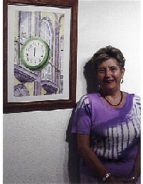 La autora, junto a una acuarela suya sobre el reloj situado en la calle Triana de Las Palmas de Gran Canaria